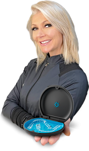Dra. Camille van der Broocke sorrindo, segurando o estojo aberto com os alinhadores Invisalign